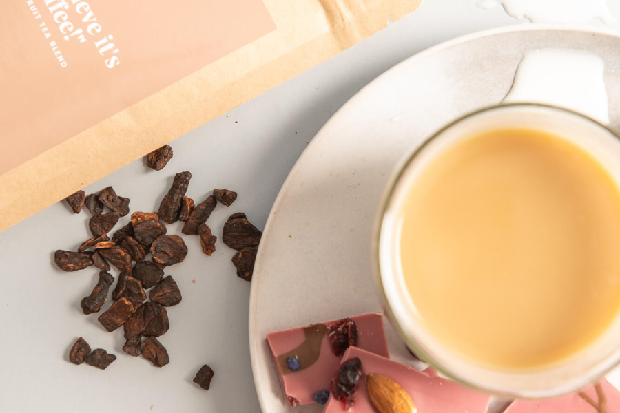 A cup of tea on a saucer with a sweet snack. Mentalitea Collective teas are 100% organic tea, hand blended loose leaf teas. 